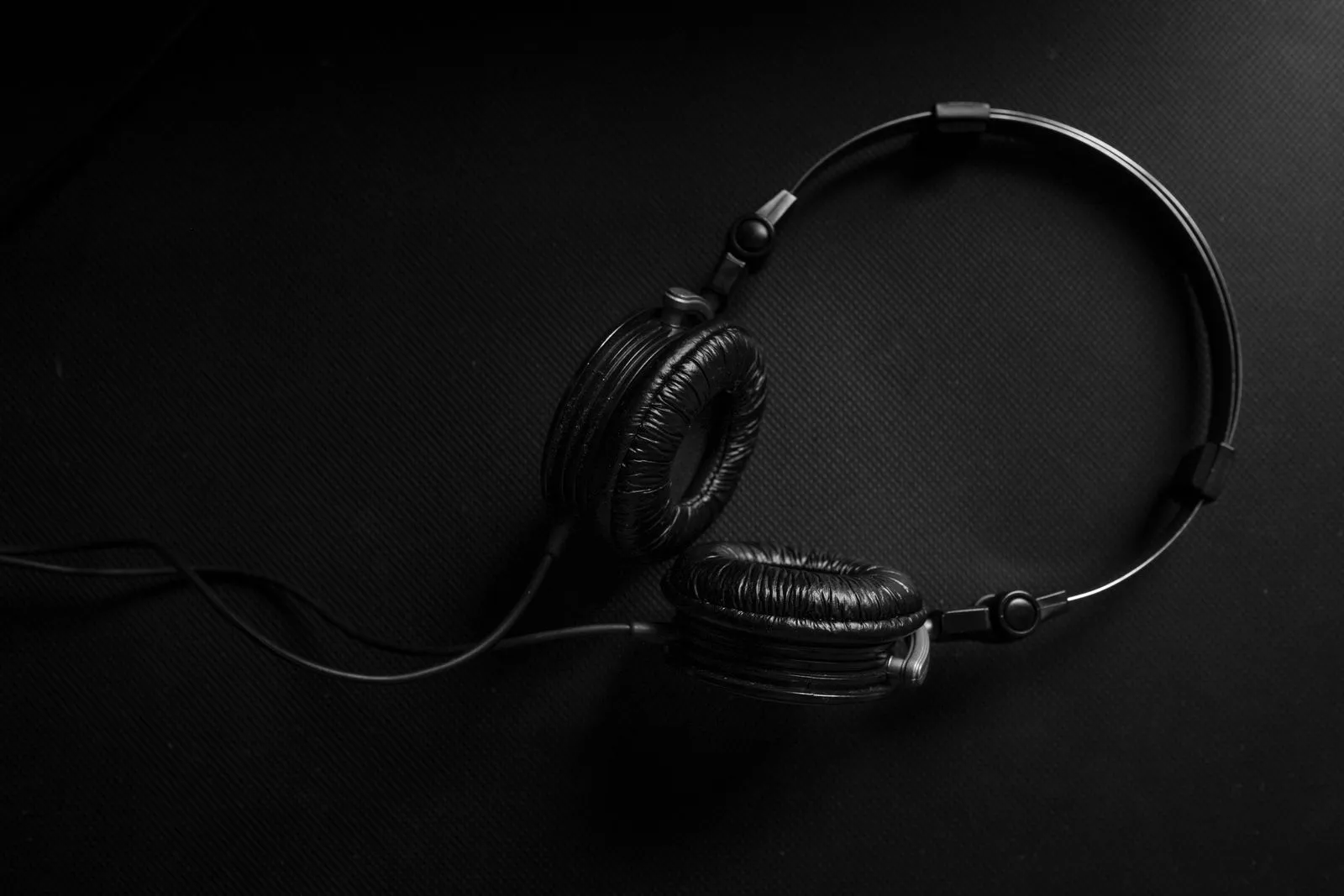 Black headphones on a dark textured surface